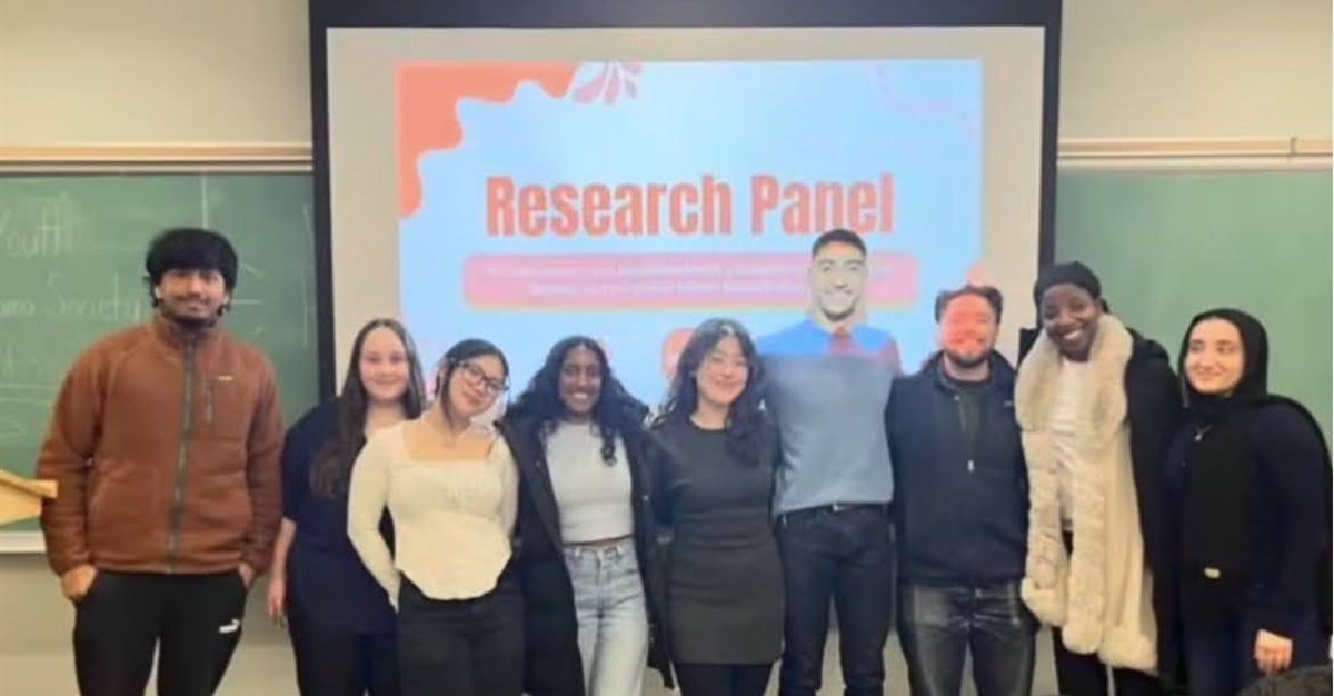 Students and guest speakers standing together after a research panel
