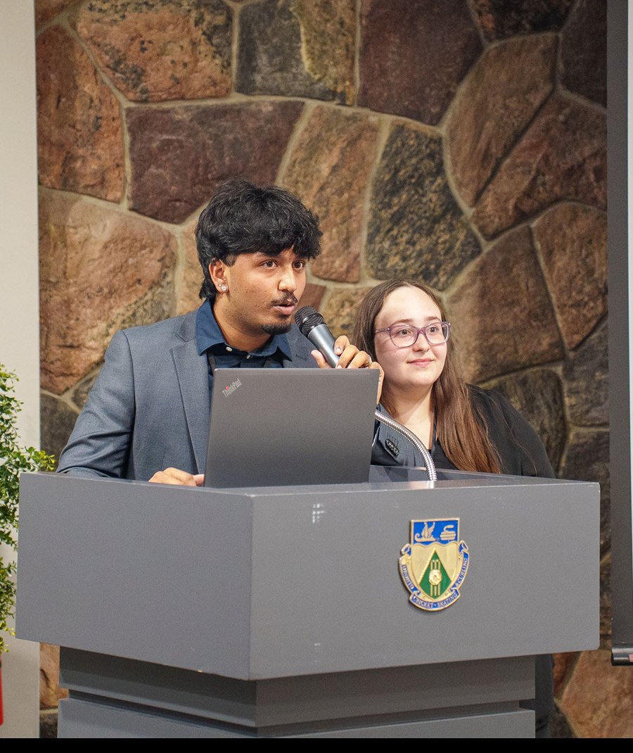 Student speaker presenting at a podium during an event