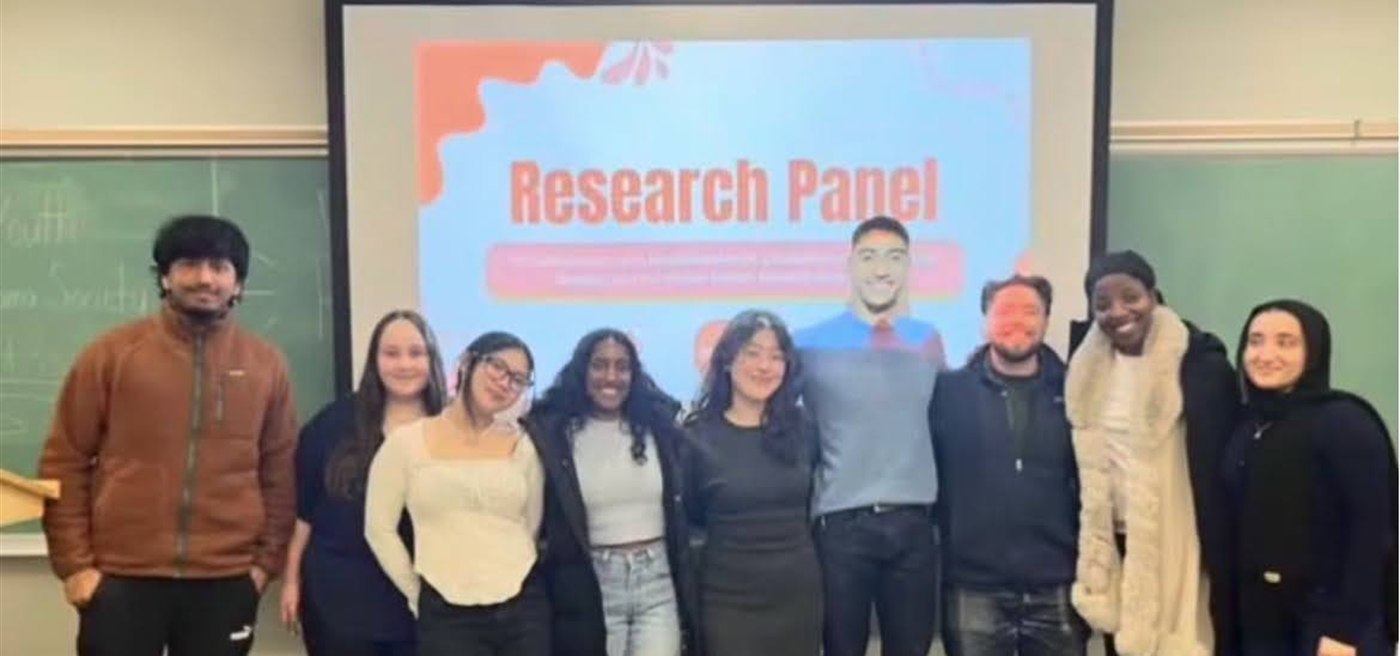 Students and guest speakers standing together after a research panel