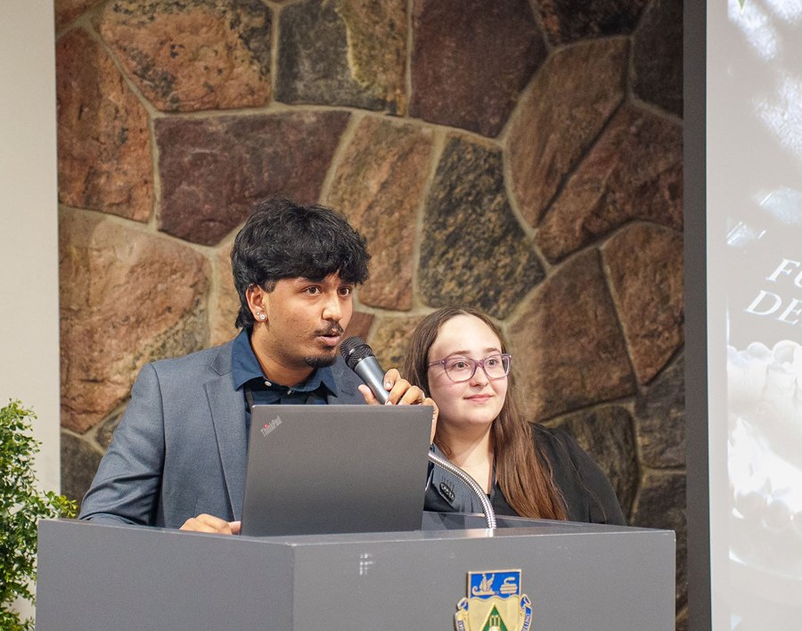 Student speaker presenting at a podium during an event